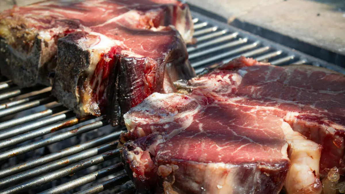 Bistecca alla fiorentina: chuletón toscano a la parrilla servido en tabla de madera